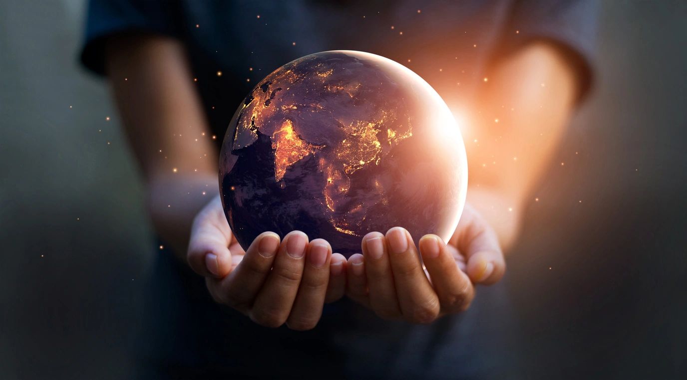 A close-up of a hand gently holding a globe, symbolizing global reach and connection.