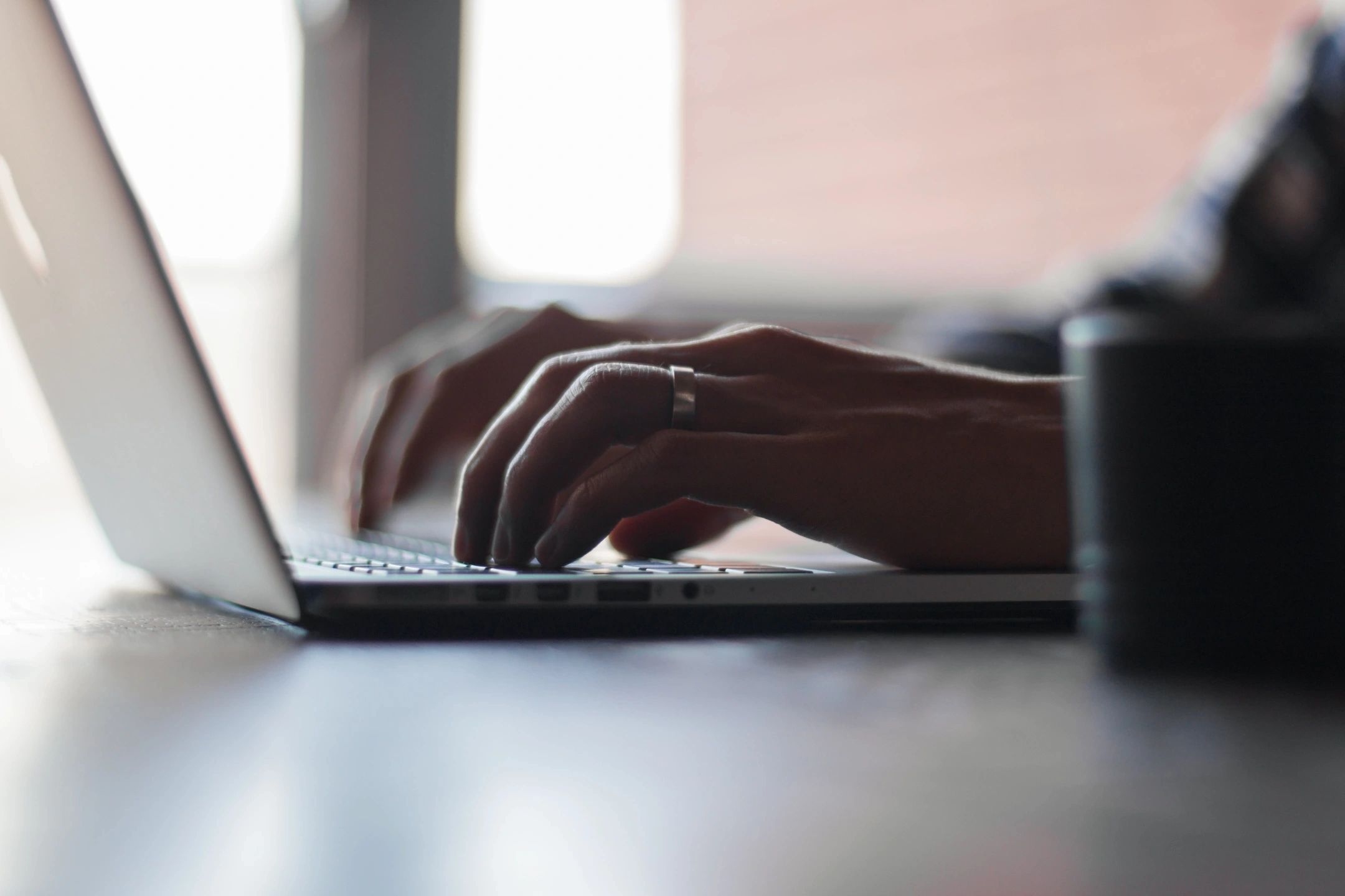 Developer's hand coding on a laptop in a software project.